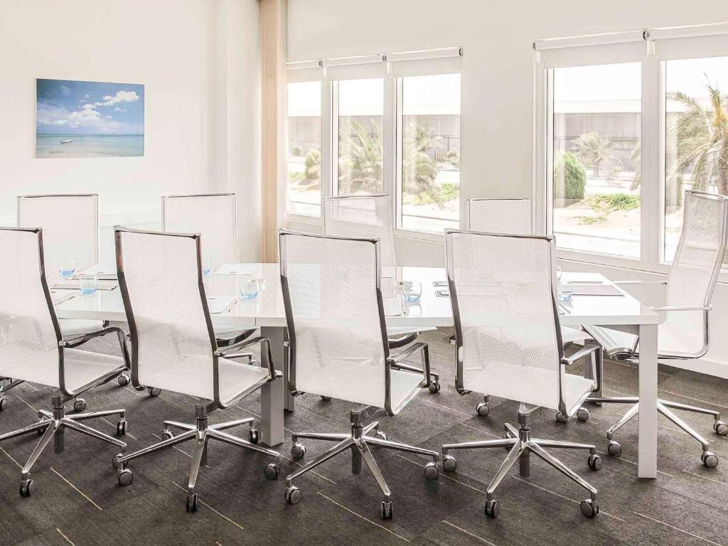 a conference room with white chairs and a table at Ibis Yanbu in Yanbu