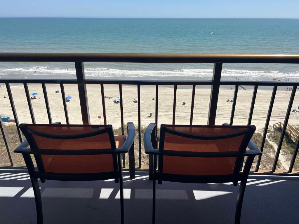 2 sedie sedute su un balcone affacciato sulla spiaggia di Best Western Ocean Sands Beach Resort a Myrtle Beach