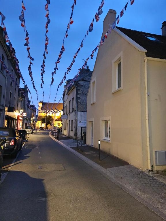 une rue avec un bâtiment et une guirlande lumineuse dans l'établissement Centre bourg Ouistreham, à Ouistreham