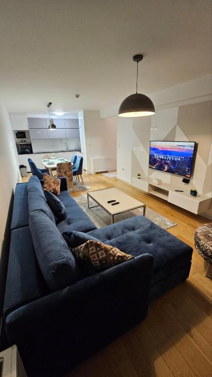 a living room with a blue couch and a tv at Apartment Lana in Sarajevo