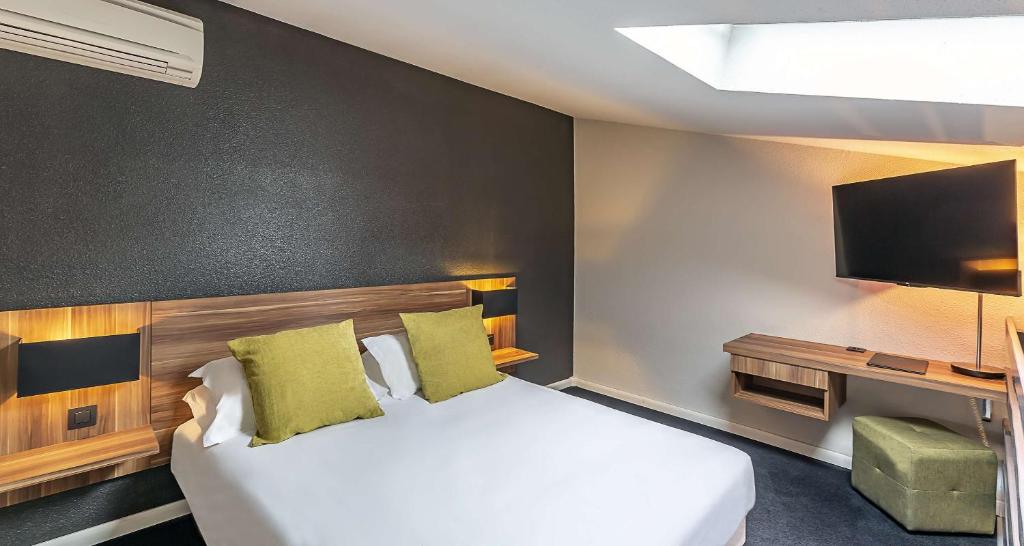 a hotel room with a bed and a flat screen tv at Best Western Hotel Atrium Valence in Valence