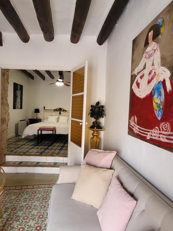 ein Wohnzimmer mit Sofa und ein Schlafzimmer in der Unterkunft Casa de pueblo, entre mar y montaña, con spa. Plaza Mayor in Sant Jordi