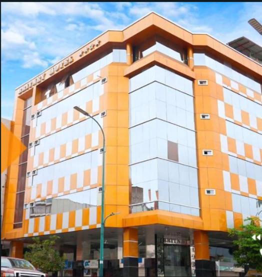 un gran edificio con una naranja y blanco en BRITNEY HOTEL Machala, en Machala