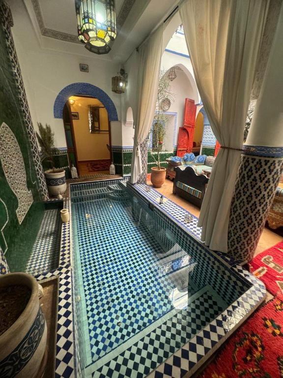 a living room with a pool in the middle of a room at Riad Assalam in Marrakech