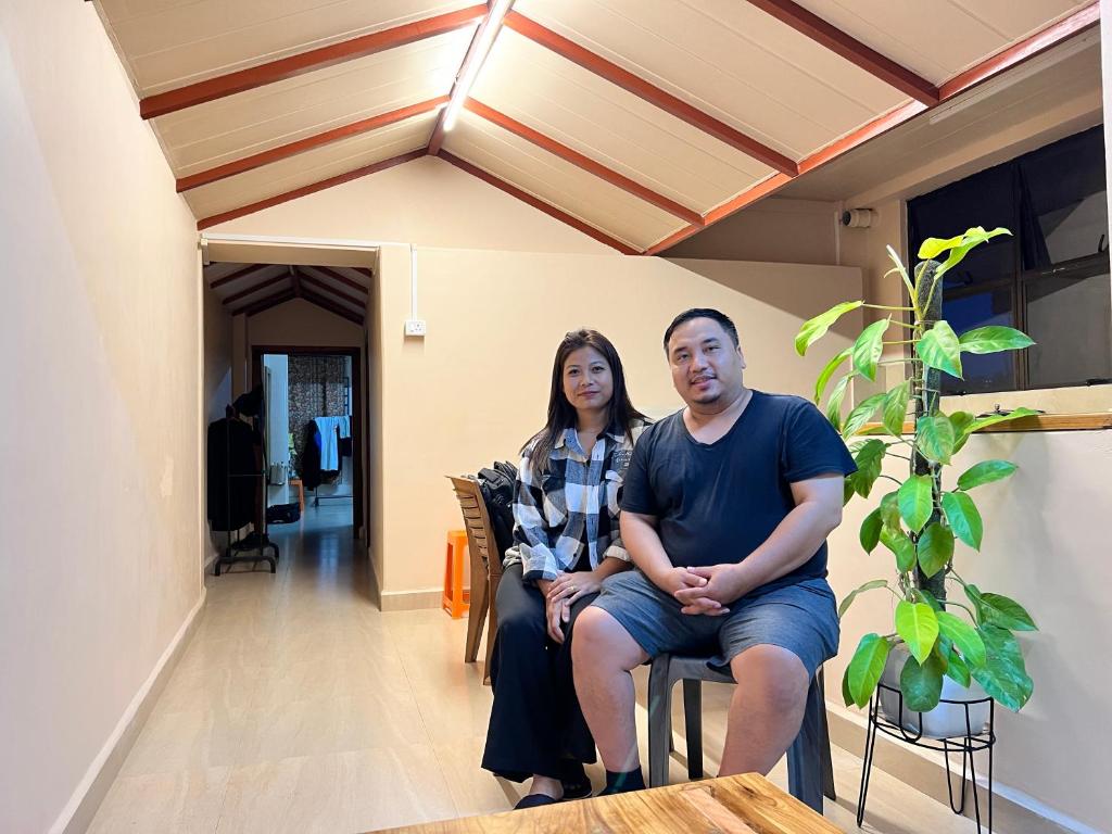 Un hombre y una mujer sentados en sillas en una casa. en Zaras Cottage, en Āīzawl