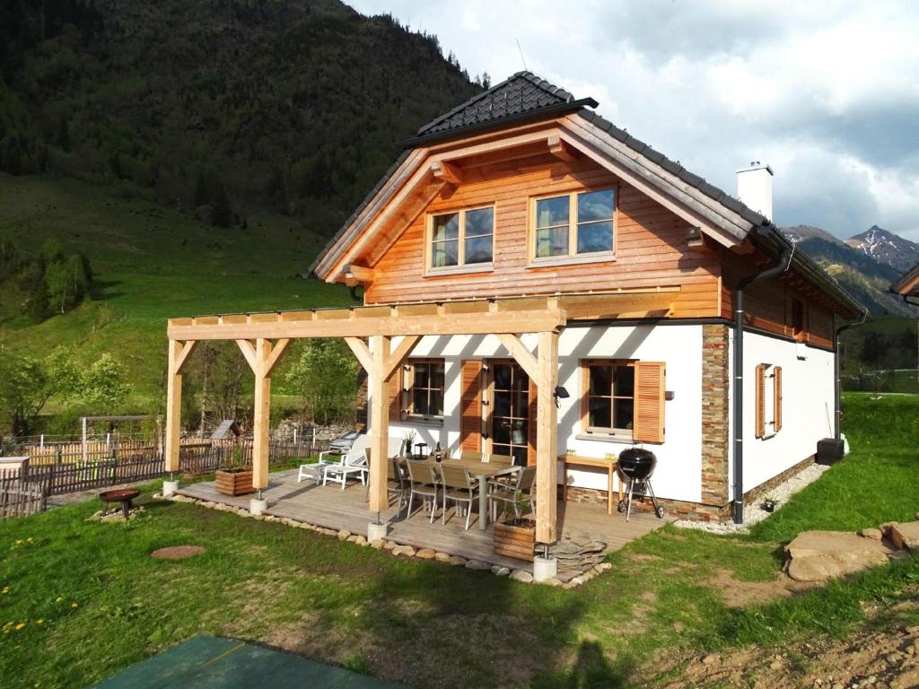 een blokhut met een terras en een huis bij Chalet Amsel in Donnersbachwald