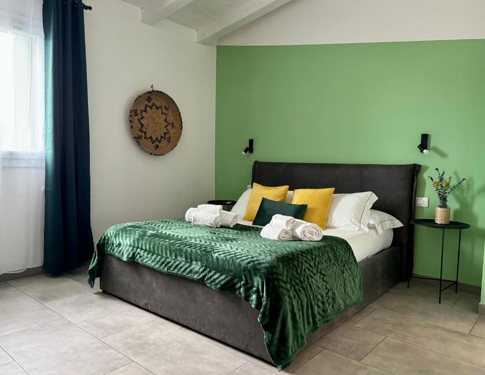una camera da letto con un letto con cuscini verdi e gialli di Citroom - green city rooms a Olbia