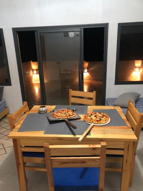 two pizzas are sitting on a wooden table at apartment vue Mer in Agadir