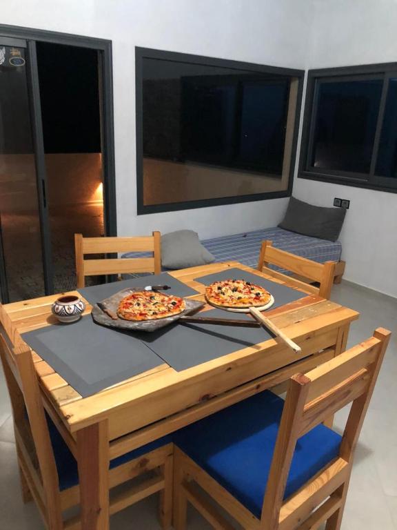 two pizzas are sitting on a wooden table at apartment vue Mer in Agadir