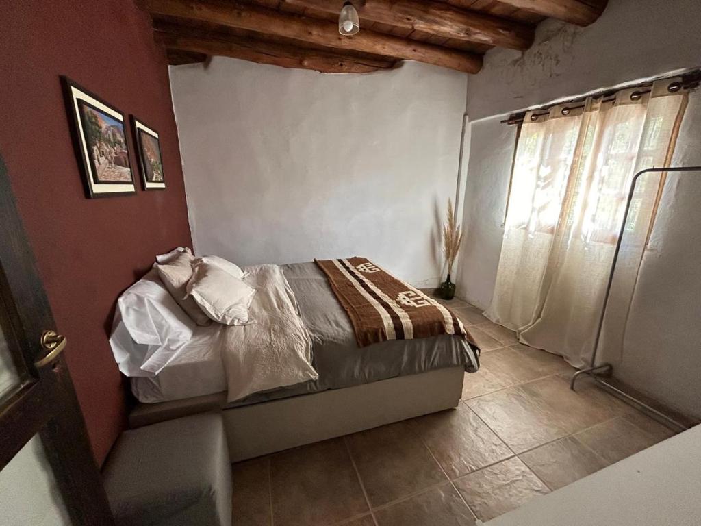 a bedroom with a bed in a room with a window at Casa en el corazón de Huacalera, Jujuy in Tilcara