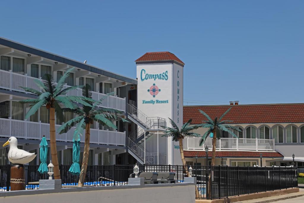 a hotel with a sign for a resort with palm trees at Compass Family Resort in Wildwood Crest