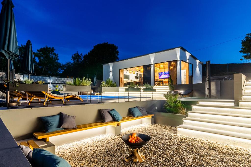 a house with a fire pit in front of it at Jackal Holiday House with a heated pool and a jacuzzi in Lovreć