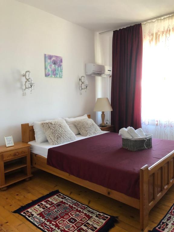 a bedroom with a large bed with a purple blanket at Vila Rianna in Dunavăţu de Jos