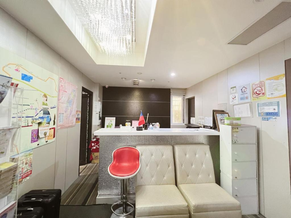 eine Küche mit einer Bar mit einem roten Stuhl in der Unterkunft Fuyale Hotel in Taipeh