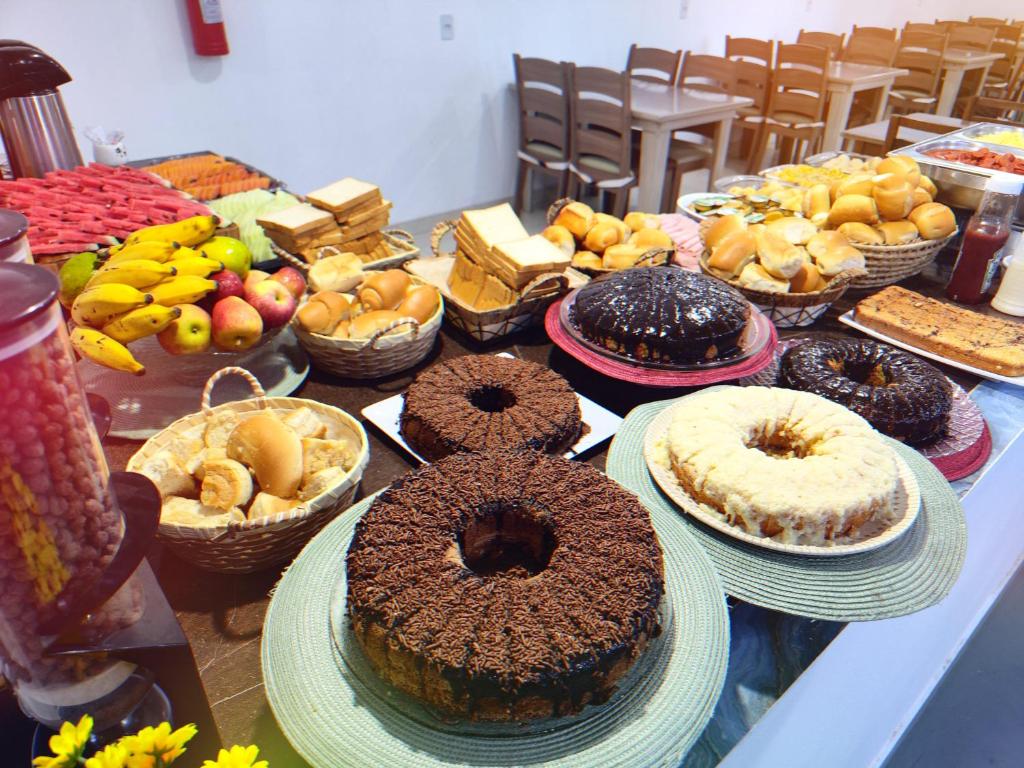 uma mesa com muitos tipos diferentes de bolos e outros alimentos em Pousada Helena em Penha