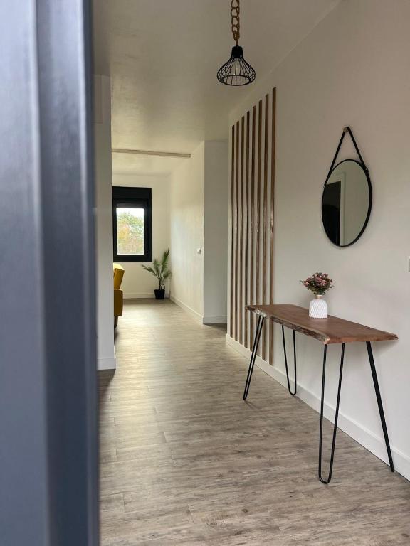 a hallway with a table and a mirror on the wall at Apartamento A Cachola in Cangas de Morrazo