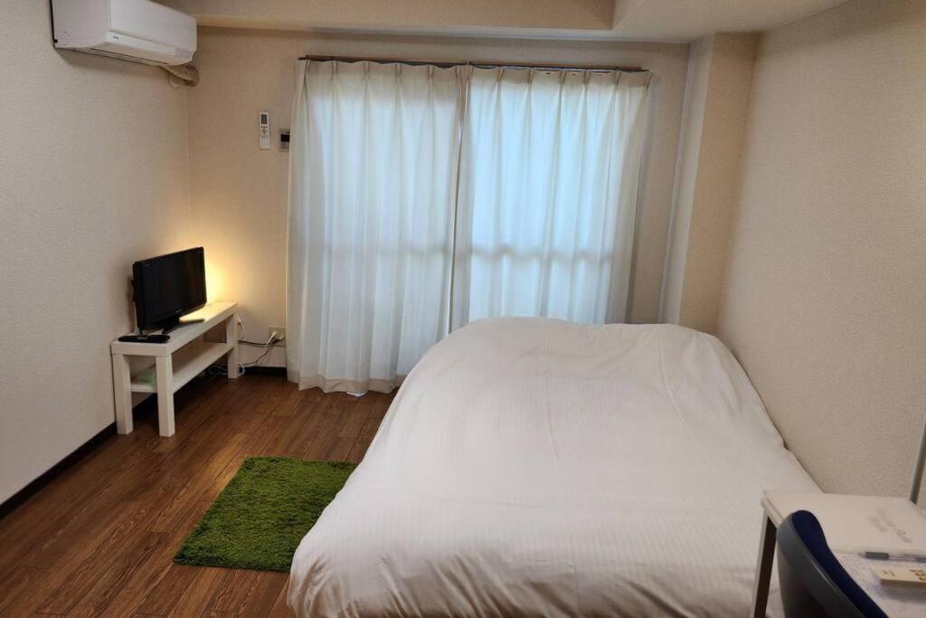 Ένα ή περισσότερα κρεβάτια σε δωμάτιο στο ハイムユアーズ207