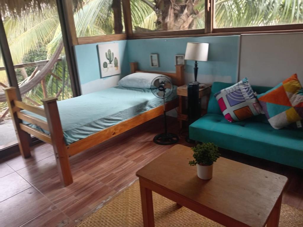 a bedroom with a bed and a couch and a table at El Puente in El Paredón Buena Vista