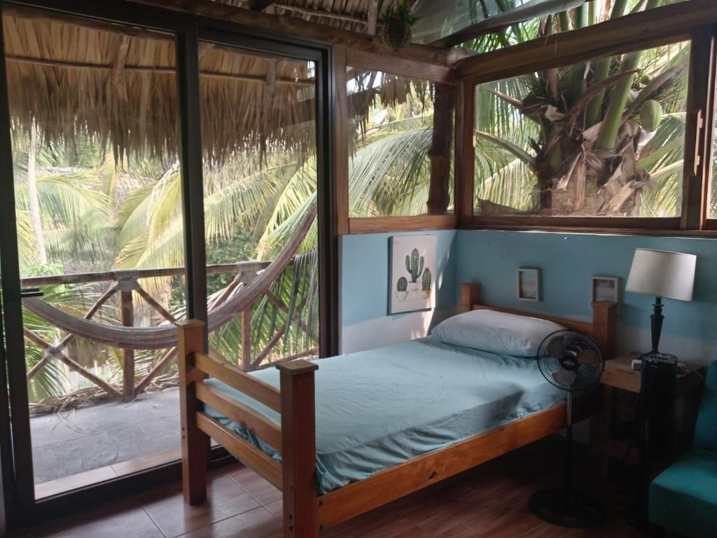 a bedroom with a bed and a large window at El Puente in El Paredón Buena Vista