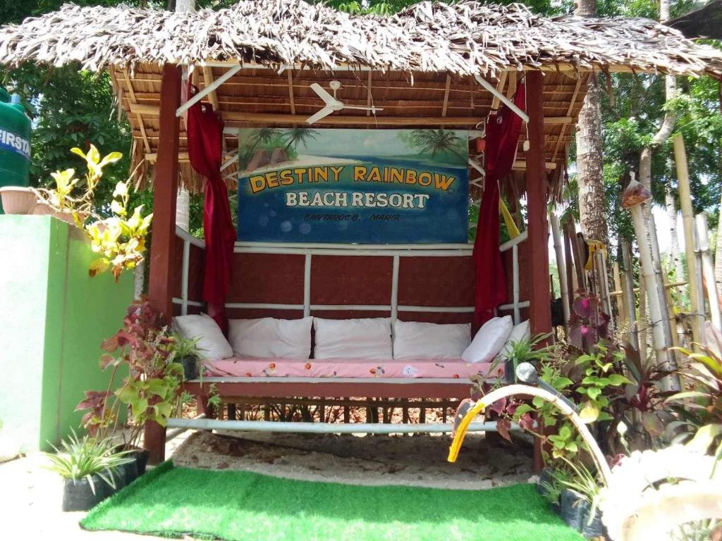 a bench in a gazebo with a sign at Destiny Rainbow Beach Resort in Siquijor