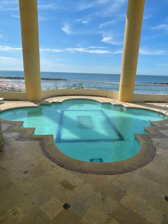 ein Schwimmbad mit dem Ozean im Hintergrund in der Unterkunft Cabrero Beach 1111 in Cartagena de Indias
