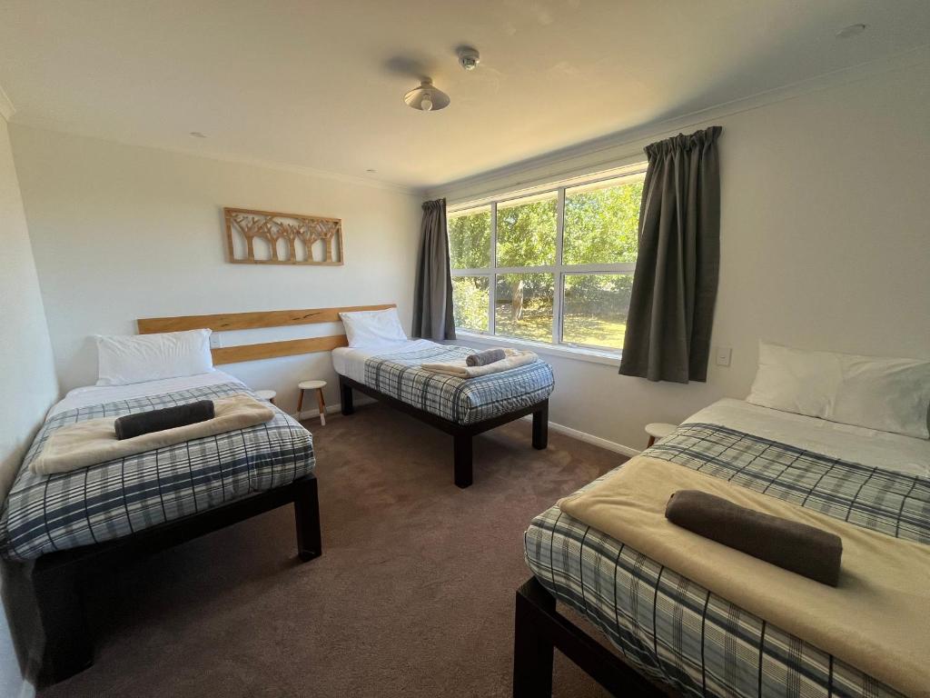 um quarto com duas camas e uma janela em Tailor Made Tekapo Accommodation - Guesthouse & Hostel em Lake Tekapo