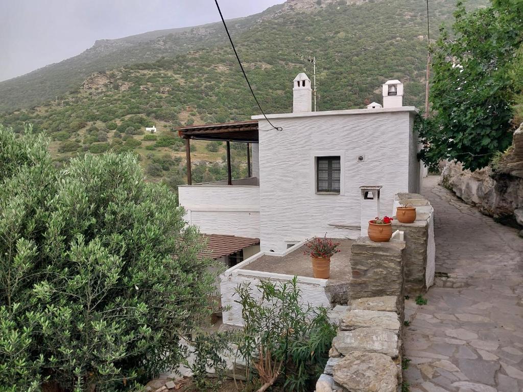 a small white church with a hill in the background at Village Sense, Pergola & Unlimited View in Andros