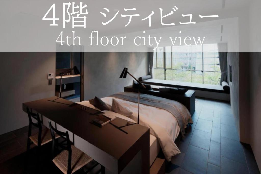 a bedroom with a bed and a desk and a window at SGR鴨川 in Gionmachi