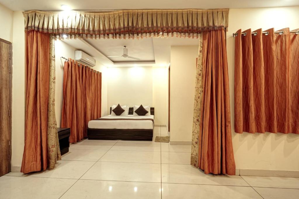 a bedroom with a bed with orange curtains at Hotel New City Lite in New Delhi