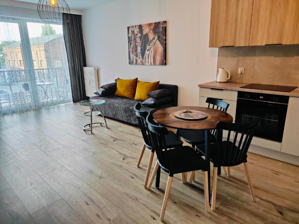 a kitchen and a living room with a table and chairs at Red Kot Lisia 12 in Zielona Góra