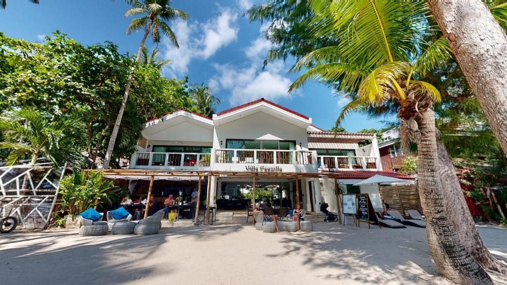 a building on the beach with palm trees at Villa Caemilla Beach Boutique Hotel in Boracay
