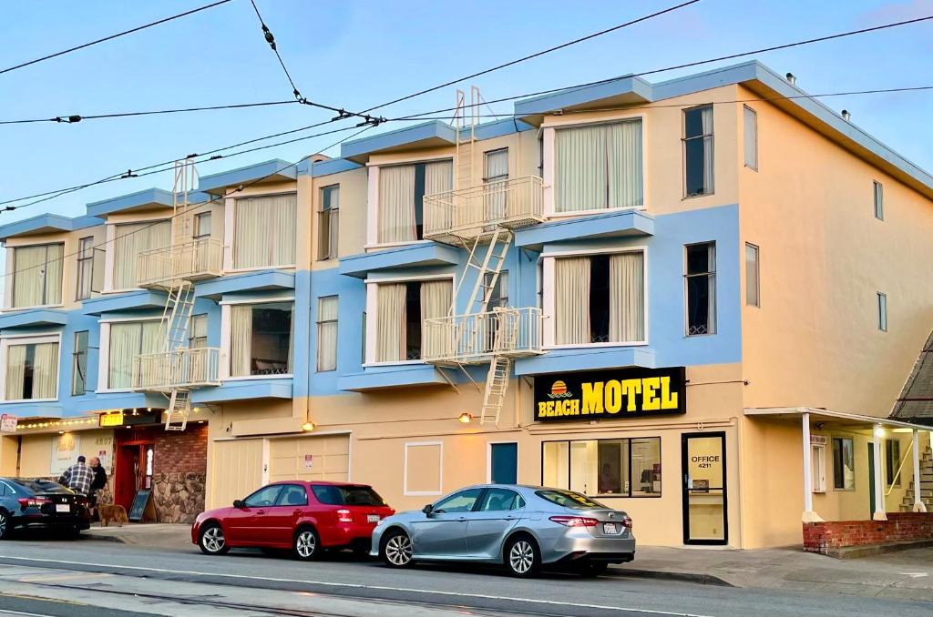 サンフランシスコにあるビーチ モーテルの建物の前に駐車した車両2台