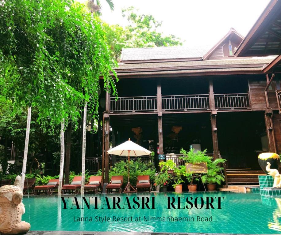 un complexe avec une piscine en face d'une maison dans l'établissement Yantarasri Resort, à Chiang Mai