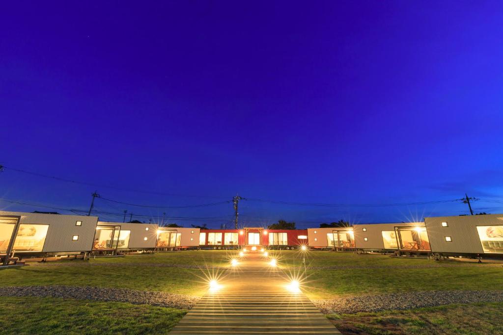 szereg budynków w nocy z oświetleniem na ziemi w obiekcie Oruga Resort -Trailer Cottage & Cafe - w mieście Sakai