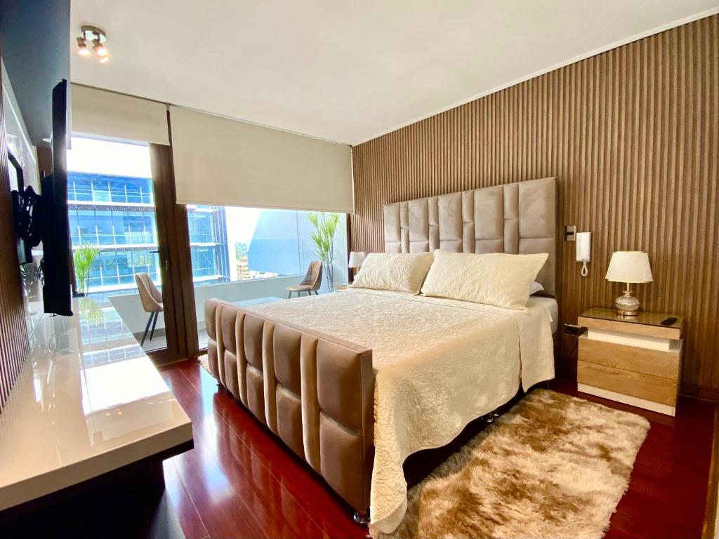a bedroom with a large bed and a large window at Exclusive Apt Parque San Damin in Santiago