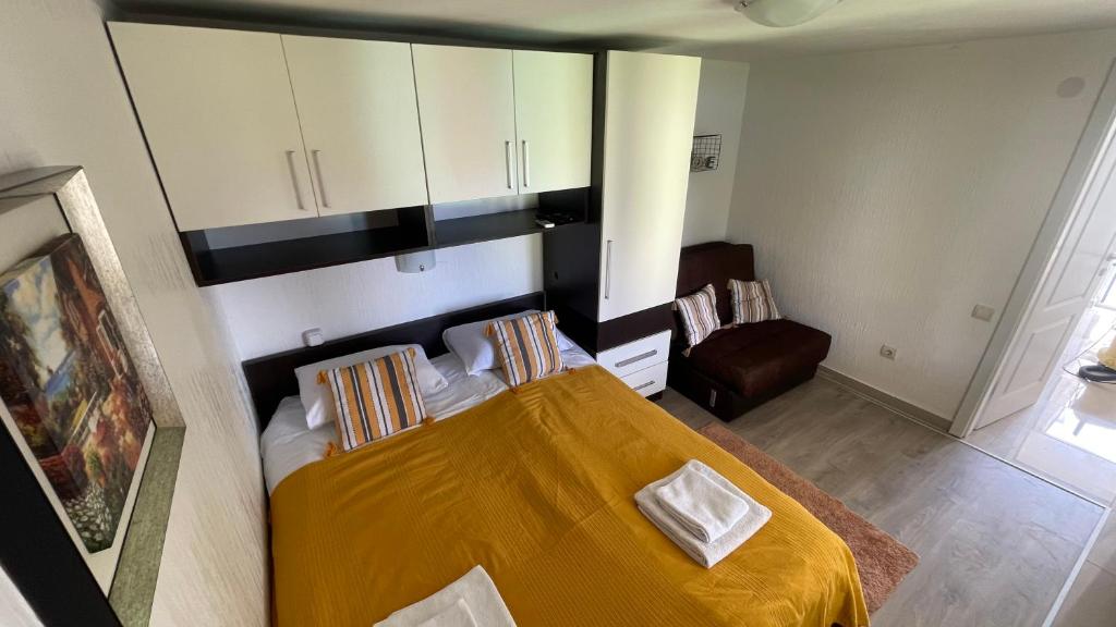1 dormitorio con 1 cama con manta amarilla en Family House with pool & sea view, en Bijela