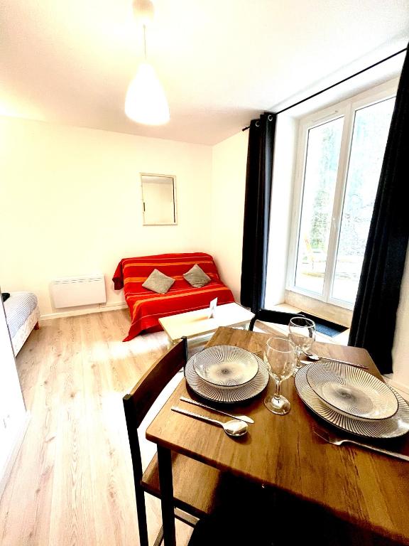 un salon avec une table et un canapé dans l'établissement Appartement avec terrasse au coeur d'Aurillac, à Aurillac