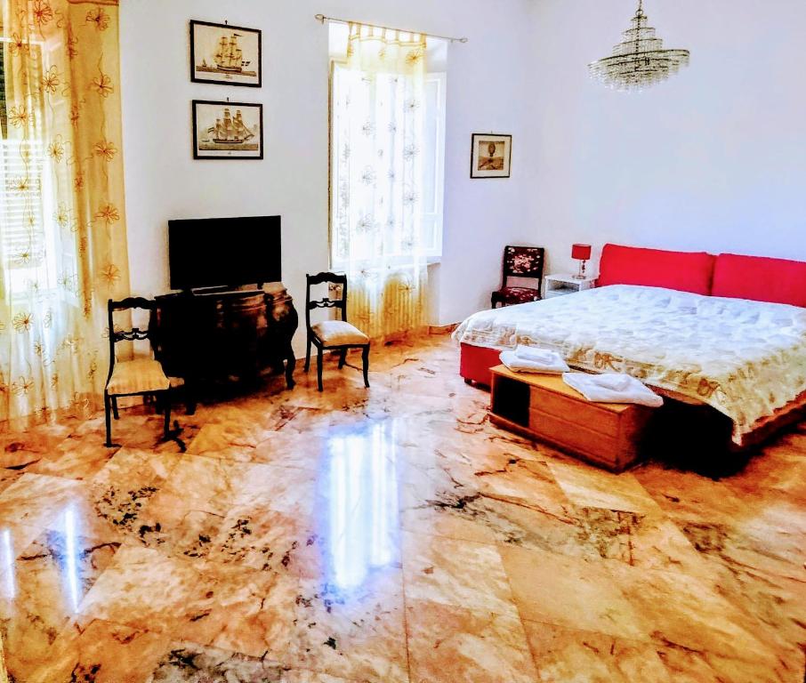 Dormitorio con cama, escritorio y TV en GABRY'S Cozy 3-bedroom big apartment near city center & station en Livorno