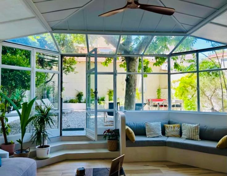un salon avec un canapé bleu et une grande fenêtre dans l'établissement Bord de mer, magnifique appartement de 150m2 avec jardin, à Marseille