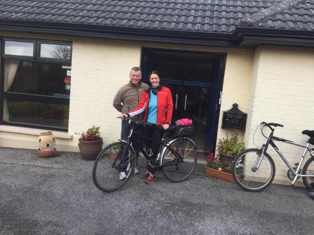 Dois homens em frente a uma casa com as suas bicicletas. em Shelmalier House em Athlone