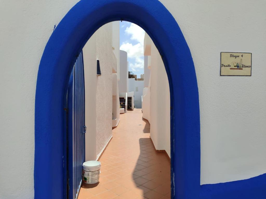 Un pasillo con un arco azul en un edificio. en Apartamento La Amatista, en La Isleta del Moro