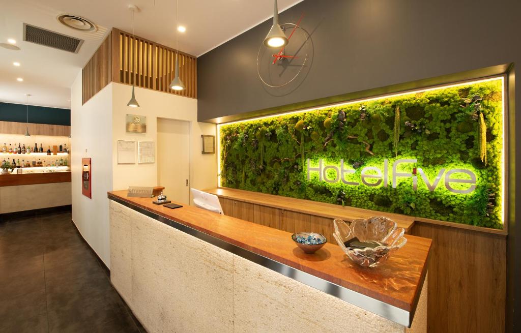 um restaurante com um grande aquário verde na parede em Hotel Five em Milão