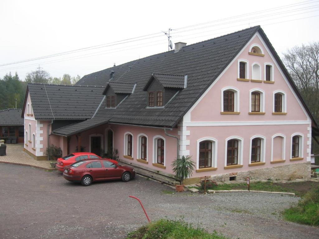 una casa con una macchina rossa parcheggiata di fronte di Restaurace A Penzion U Pešíků a Červený Kostelec