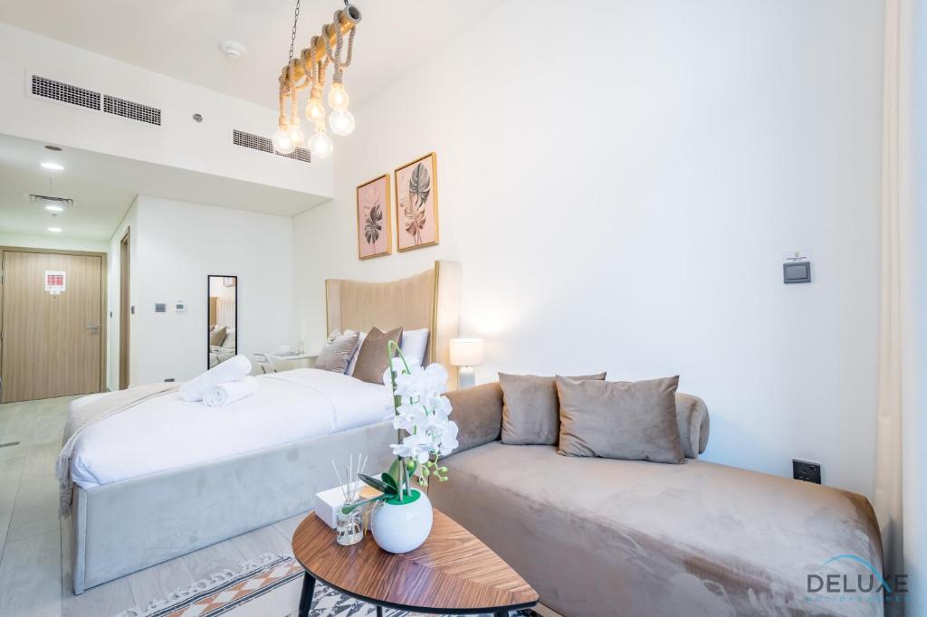 a living room with a bed and a couch at Charming Studio at Azizi Riviera 32, Al Merkadh by Deluxe Holiday Homes in Dubai