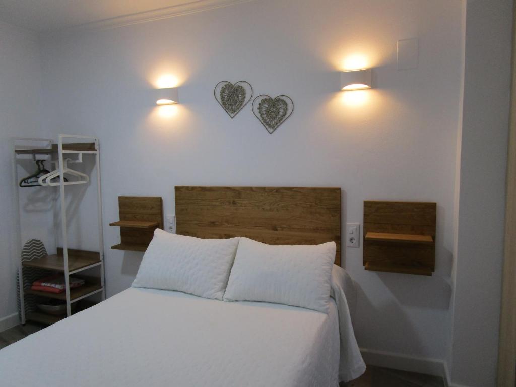 ein Schlafzimmer mit einem Bett mit zwei Herzen an der Wand in der Unterkunft APARTAMENTO SOL in Chipiona