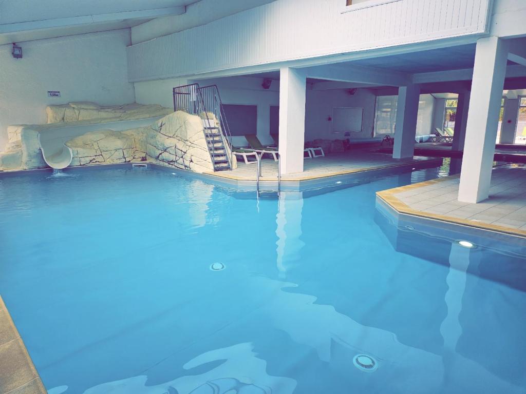 una piscina con un tobogán de agua en un edificio en Évasion océanique : Mobil-home dans un camping 4* à 50m de l'océan, en La Bétaudière