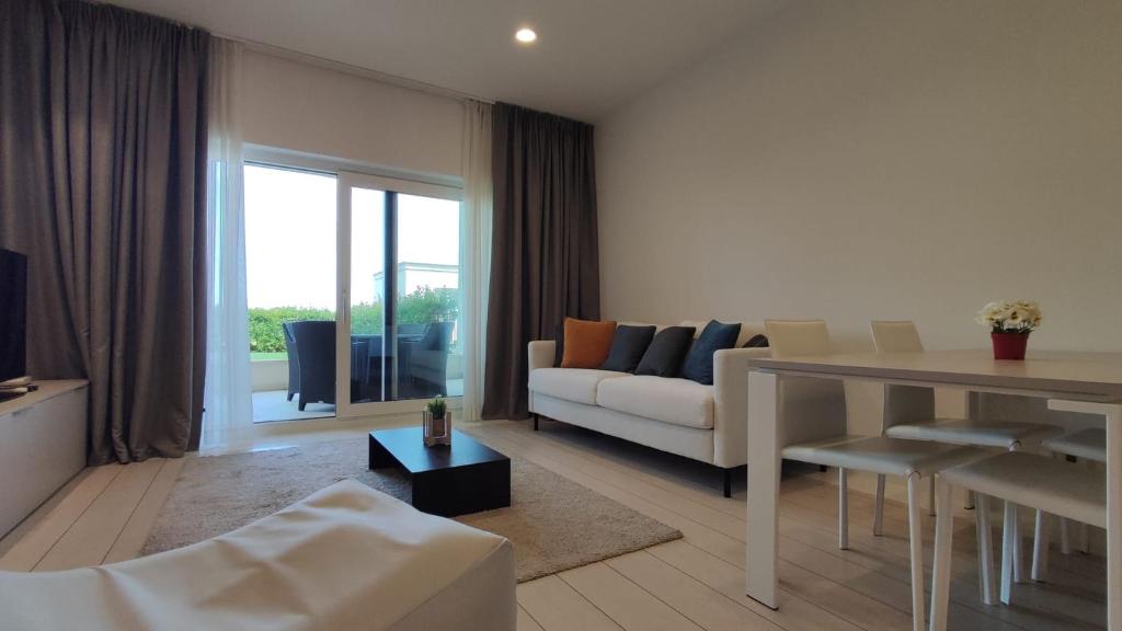 een woonkamer met een bank en een tafel bij Skiper Apartments & Golf Resort in Savudrija
