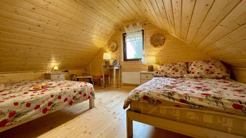 um quarto com uma cama num chalé de madeira em Chatka Dziadka Sudety em Stary Gieraltow
