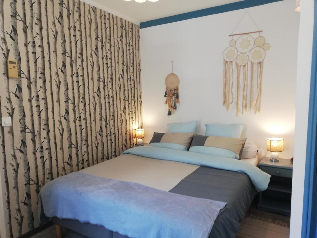 una camera con letto e lenzuola bianche e blu di Le Coty a Fécamp