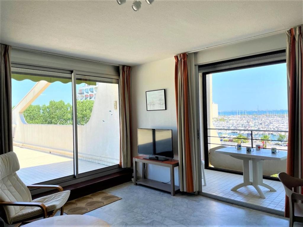 un salon avec une grande fenêtre avec vue dans l'établissement La Grande-Motte: Appart 3 chambres, terrasse, parking, clim, WIFI - FR-1-790-14, à La Grande Motte